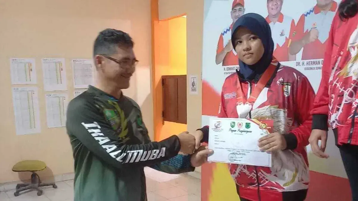 Ketua Pengcab Menembak Muba H. Pathi Riduan menyerahkan medali kepada atlet peraih emas pada ajang Porprov XV Sumsel 2025. (Sumber: Istimewa)